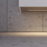 Minimalistisk og stilrent badeværelse inspiration med vaskeskab, underskabe og højskabe i gylden eg, stort rundt spejl med lysstyring, farvet toilet og bordstående håndvask