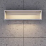 Lille, stilfuldt badeværelse med mørkeblå vægge, bløde gule badeværelsesmøbler med riller, og elegant rundt spejl med lampe
