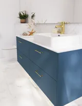 Badeværelse inspiration med badeværelsesmøbler i moderne blå farve, elegant bordstående vask og stort firkantet spejl med lys, hvide sildebensfliser giver et stilfuldt og klassisk udtryk