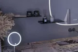 Stort badeværelse inspiration med grå vaskeskab med integreret greb, stilfuld sidestillet håndvask, firkantet spejl med afrundede hjørner, vægge i beton look samt rå materialer giver et urban udtryk