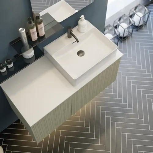 Badeværelse med skrå loft inspiration, beige badeværelsesmøbler med rifler, elegant bordplade samt firkantet bordstående håndvask, smukt firkantet spejl med stilfulde hylder, blå vægge, store vinduer og sort sildebensgulv giver et lyst og urban udtryk.