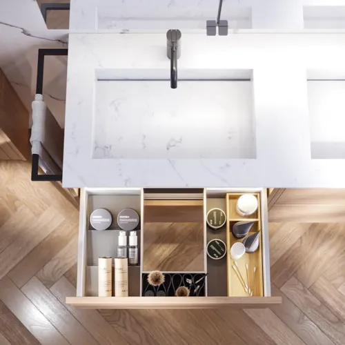 Badeværelse inspiration med vaskeskabe samt overskabe i lys eg med lameller, elegant dobbelt håndvask, smukt spejlskab med lys, sildebensgulv i lys træ og hvid marmorvæg giver et klassisk, lyst og stilrent udtryk.