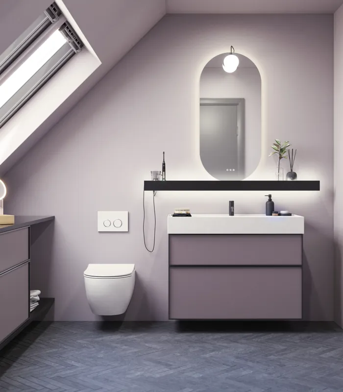Badeværelse med skrå vægge inspiration, med badeværelsesmøbler i lilla med elegante rammefronter, flot ovalt spejl med lampe, smuk og praktisk hylde, samt lillamalet væg og gråt sildebensgulv, der giver et elegant og moderne udtryk.
