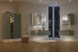 Stort badeværelse inspiration i nordisk stil med badeværelsesmøbler i lys blå farve og træbordplade med elegant bordstående håndvask, sildebensgulv i træ, der skaber en lys og klassisk stil