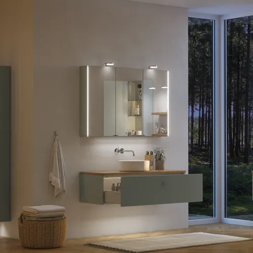 Stort badeværelse inspiration i nordisk stil med badeværelsesmøbler i lys blå farve og træbordplade med elegant bordstående håndvask, sildebensgulv i træ, der skaber en lys og klassisk stil