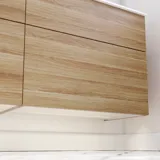 Nordisk badeværelse i træ med flotte runde spejle med sort kant og masser af opbevaring i badeværelsesmøblet