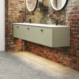 Råt og moderne badeværelse i urban stil. Flotte vaskeskabe og runde spejle med sort kant