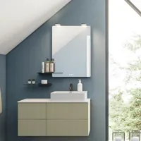 Badeværelse med skrå loft inspiration, beige badeværelsesmøbler med rifler, elegant bordplade samt firkantet bordstående håndvask, smukt firkantet spejl med stilfulde hylder, blå vægge, store vinduer og sort sildebensgulv giver et lyst og urban udtryk.