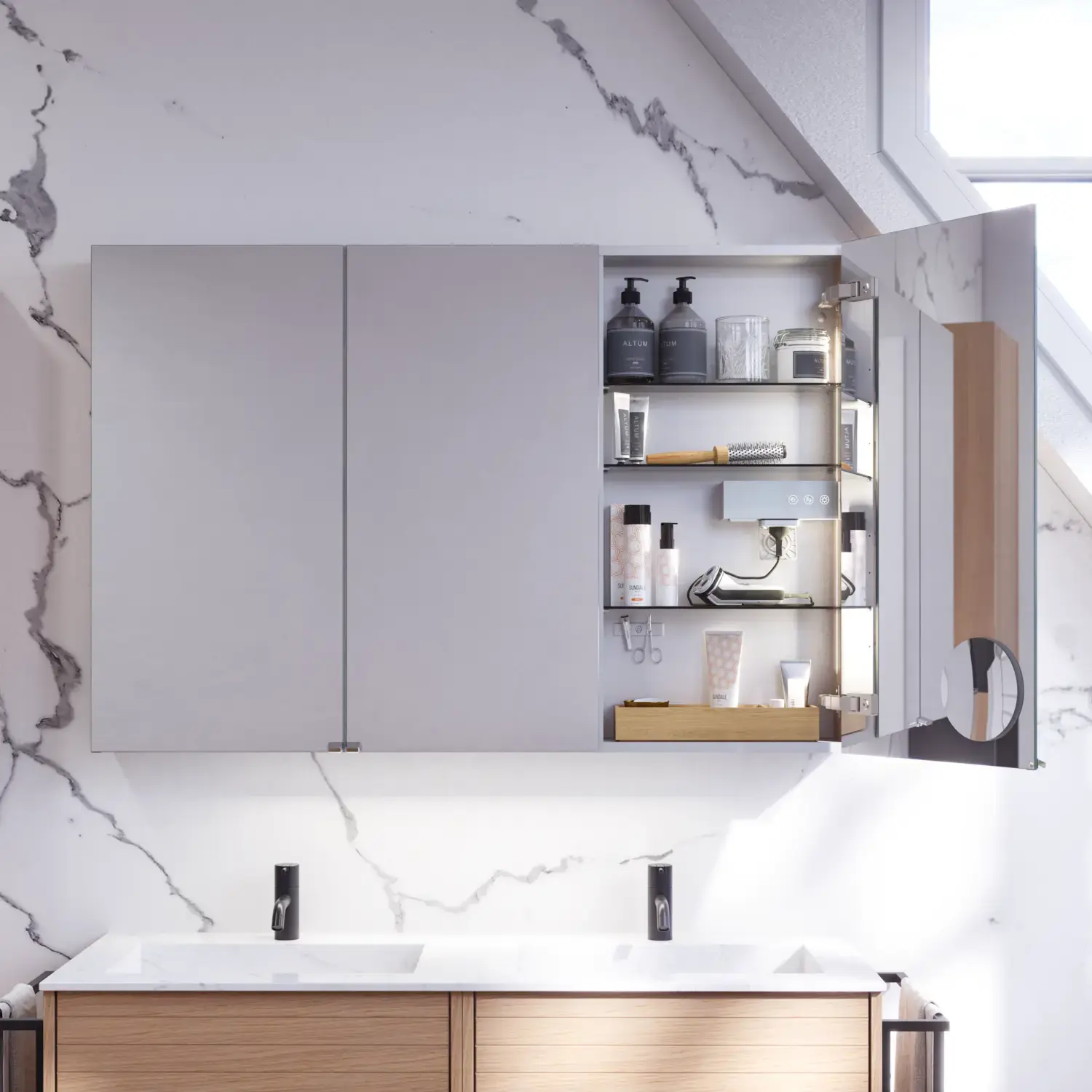 Badeværelse inspiration med vaskeskabe samt overskabe i lys eg med lameller, elegant dobbelt håndvask, smukt spejlskab med lys, sildebensgulv i lys træ og hvid marmorvæg giver et klassisk, lyst og stilrent udtryk.