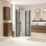 Stort badeværelse inspiration med badeværelsesmøbler i brun eg med sorte rammefronter, elegant dobbeltvask samt sort hylde, firkantede spejle med afrundede hjørner, sort hjørnebrus med foldedøre, hvide fliser og beige vægge giver et moderne udtryk