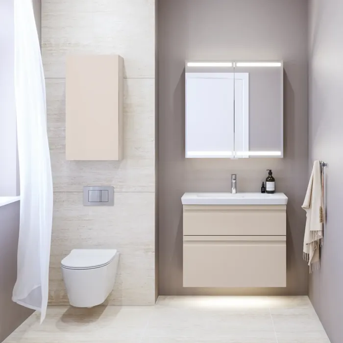 Lille badeværelse inspiration med vaskeskab og overskab over toilet i beige specialfarve, elegant spejlskab med integreret lys, de lyse farver og hvide gardin skaber en romantisk og feminin atmosfære.