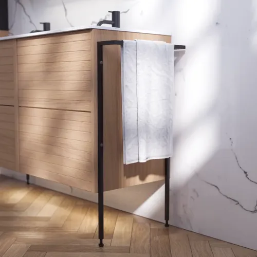 Badeværelse inspiration med vaskeskabe samt overskabe i lys eg med lameller, elegant dobbelt håndvask, smukt spejlskab med lys, sildebensgulv i lys træ og hvid marmorvæg giver et klassisk, lyst og stilrent udtryk.