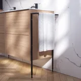 Badeværelse inspiration med vaskeskabe samt overskabe i lys eg med lameller, elegant dobbelt håndvask, smukt spejlskab med lys, sildebensgulv i lys træ og hvid marmorvæg giver et klassisk, lyst og stilrent udtryk.