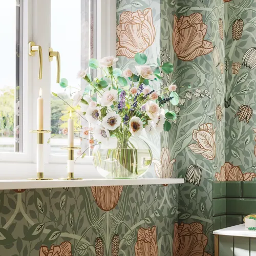 Badeværelse inspiration med grønne møbler i specialfarve med sider i natur eg, elegante riller, stilfuld bordplade med romantisk oval håndvask, smukt ovalt spejl og blomstret tapet giver et yndefuldt, vintage retro udtryk.