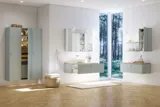 Stort badeværelse inspiration i nordisk stil med badeværelsesmøbler i lys blå farve og træbordplade med elegant bordstående håndvask, sildebensgulv i træ, der skaber en lys og klassisk stil
