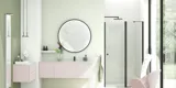 Stort og lyst badeværelse i minimalistisk stil med bløde pastelfarver og elegante grønne nuancer, stilfuldt rundt spejl og moderne indretning