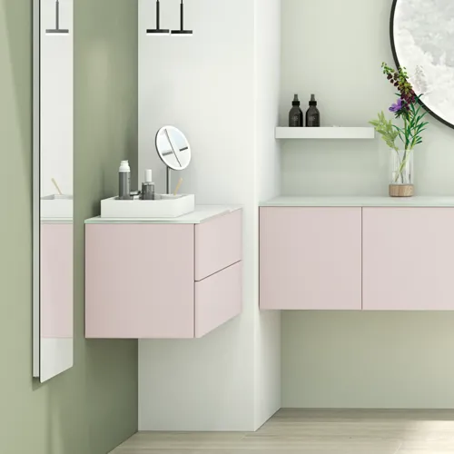 Stort og lyst badeværelse i minimalistisk stil med bløde pastelfarver og elegante grønne nuancer, stilfuldt rundt spejl og moderne indretning