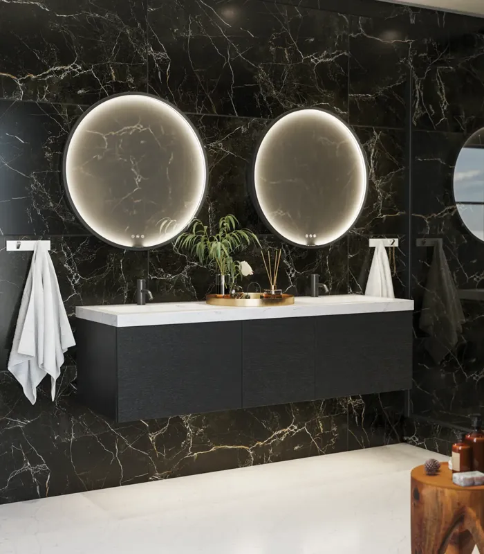 Elegant og moderne badeværelse inspiration med mørke marmorvægge, runde oplyste spejle med sort ramme, væghængt vaskeskab med dobbeltvask og en rummelig bruseniche