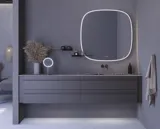 Stort badeværelse inspiration med grå vaskeskab med integreret greb, stilfuld sidestillet håndvask, firkantet spejl med afrundede hjørner, vægge i beton look samt rå materialer giver et urban udtryk