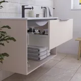 Badeværelse inspiration med lyserødt vaskeskab med elegante riller og smuk håndvask, hvide fliser på vægge og store beige fliser på gulvet giver et romantisk og feminint udtryk.