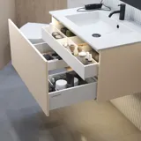 Stilfuld badeværelse inspiration med beige vaskeskab med inderskuffe, overskab, åben reol, oval spejl med belysning, matchende pendler, hylde under spejlet, og væghængt toilet. Vægge med lyse, aflange fliser