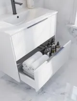 Badeværelse inspiration med hvidt vaskeskab med elegante riller og smuk håndvask, hvide marmorvægge og -gulv giver et lyst og moderne udtryk.
