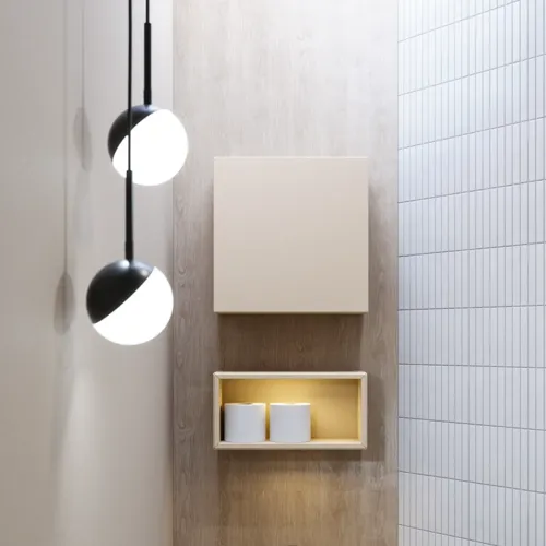 Stilfuld badeværelse inspiration med beige vaskeskab med inderskuffe, overskab, åben reol, oval spejl med belysning, matchende pendler, hylde under spejlet, og væghængt toilet. Vægge med lyse, aflange fliser