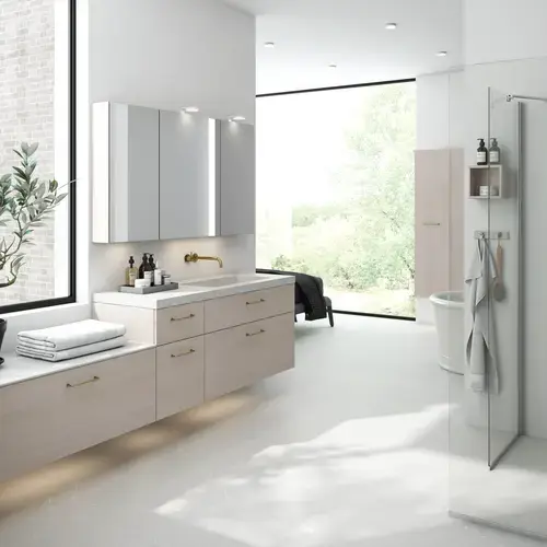 Lyst og l&#xE6;kkert badev&#xE6;relse med brusehj&#xF8;rne og bordplade i sten