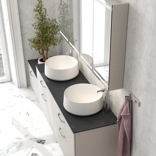 Romantisk badeværelse inspiration med spejlskab, der har praktiske og yndefulde opbevaringsløsninger, dobbelt bordstående håndvaske på en stenbordplade.