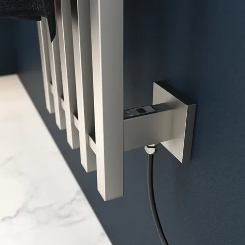 Elektrisk håndklædetørre på mørkeblå væg i stilfuldt badeværelse.