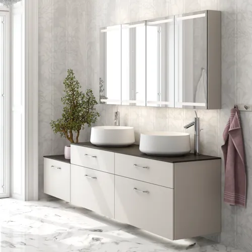 Romantisk badeværelse inspiration med spejlskab, der har praktiske og yndefulde opbevaringsløsninger, dobbelt bordstående håndvaske på en stenbordplade.