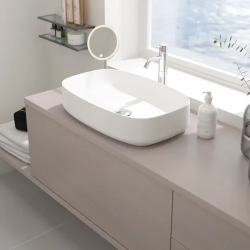 Lille badeværelse inspiration med bordplade på mål, elegant bordstående håndvask og firkantet figurspejl, der skaber et lyst og moderne rum.