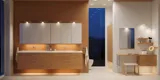 Moderne badeværelse i nordisk stil med lyst træ, elegant belysning, spejlskabsvæg og stilfuld indretning, der skaber en varm og indbydende atmosfære.