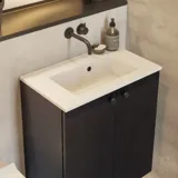 Badeværelse inspiration med vaskeskab i sort eg samt elegant rundt spejl og håndvask, lækkert tilbehør samt kaktusplanter og vægge i rå materialer giver et råt, industrielt og urban look.