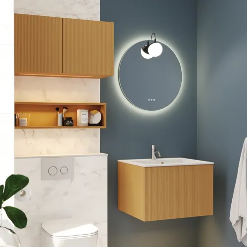 Lille, stilfuldt badeværelse med mørkeblå vægge, bløde gule badeværelsesmøbler med riller, og elegant rundt spejl med lampe