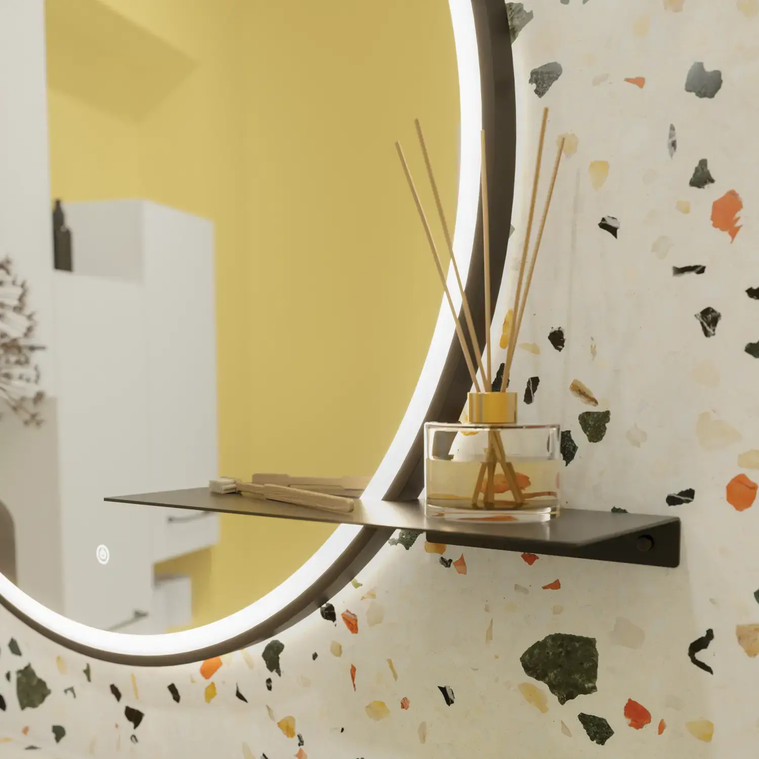 Lille badeværelse inspiration med hvide vaskeskab med sort greb og sort elegant håndvask, smukt rundt spejl med sort kant, forskudt placerede overskabe samt terrazzo væg og gulv samt gule væge giver et modigt og moderne look.