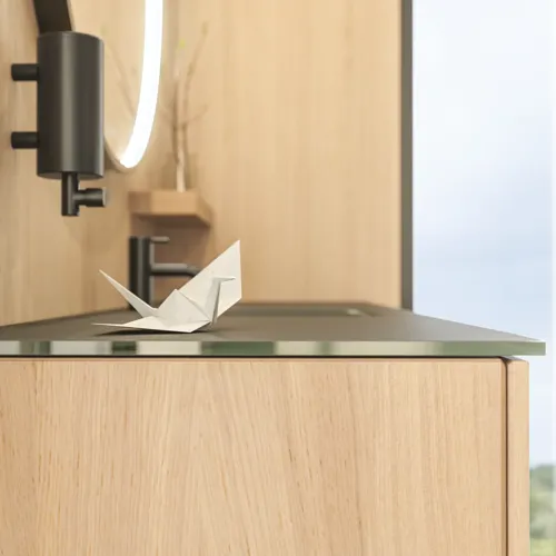 Stilfuldt badeværelse i skandinavisk og japandi indretningsstil med lyse trævægge, rundt spejl og minimalistiske badeværelsesmøbler.