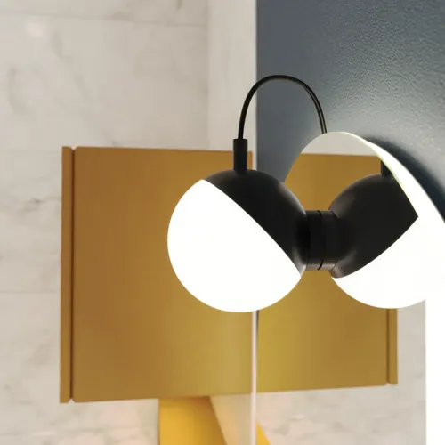 Lampe til spejl med bløde former på mørkeblå væg i stilfuldt badeværelse.