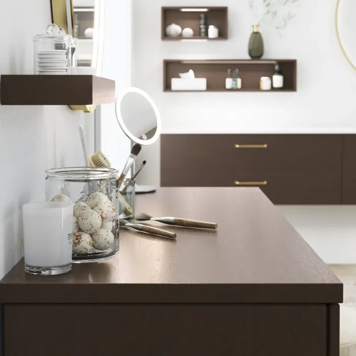 Nordisk stil badeværelse inspiration med vaskeskab og underskabe i røget eg, makeupplads, sidestillet håndvask, rundt messing spejl med ramme og synlige charmerende træbjælker.