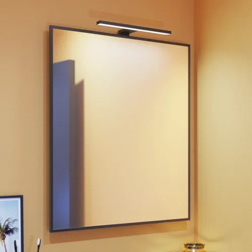 Lille badeværelse inspiration med skrå, og varm gule vægge, og minimalistisk firkantet spejl med stilren sort kant, samt elegant lampe til spejl, der tilføjer et strejf af elegance til dit badeværelse