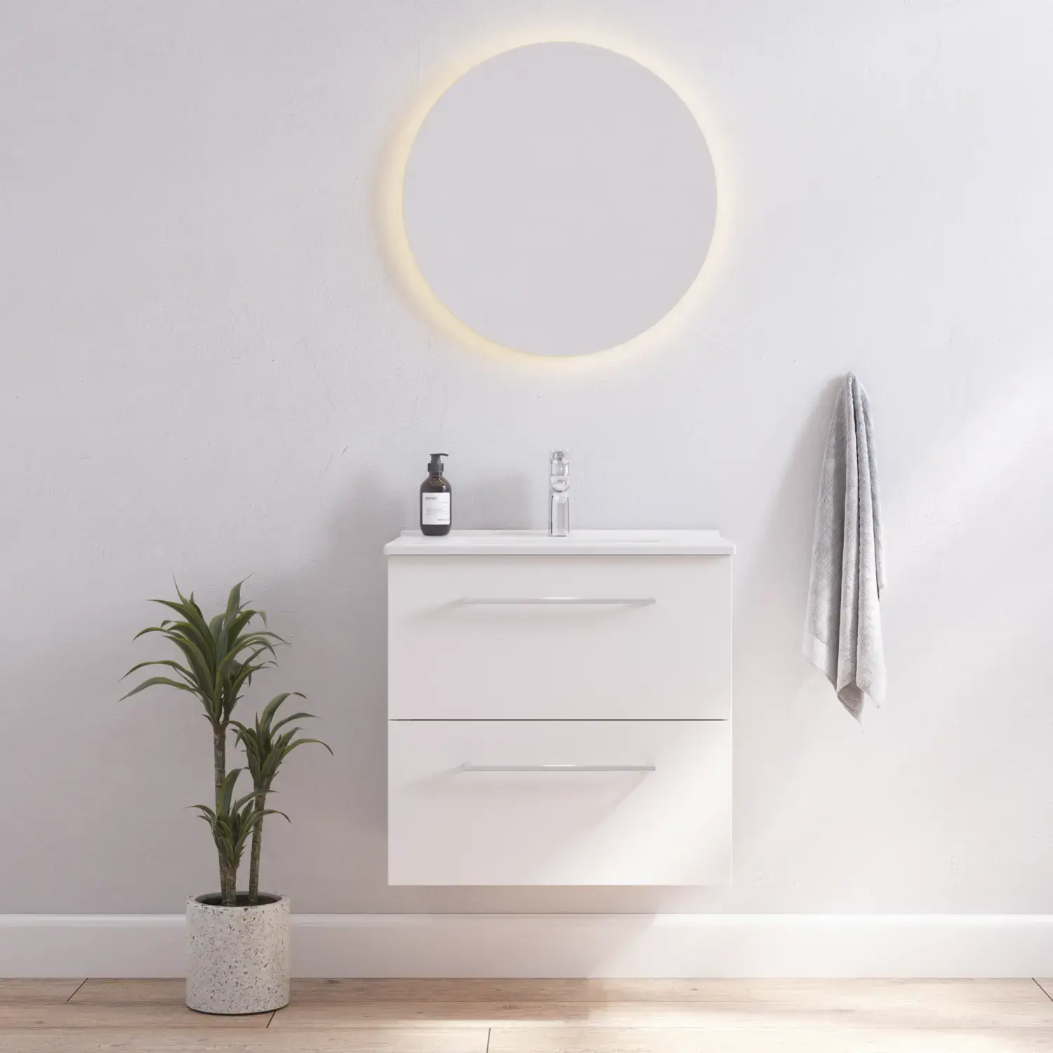 Badeværelse inspiration med smalt hvidt vaskeskab med hvide greb samt elegant håndvask med smukt rundt spejl med lys, hvide vægge og trægulv giver et lyst og minimalistisk udtryk.