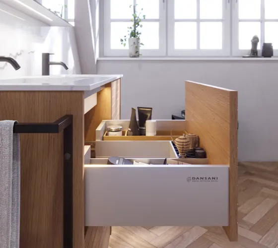 Badeværelse inspiration med vaskeskabe samt overskabe i lys eg med lameller, elegant dobbelt håndvask, smukt spejlskab med lys, sildebensgulv i lys træ og hvid marmorvæg giver et klassisk, lyst og stilrent udtryk.