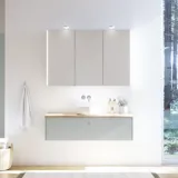 Stort badeværelse inspiration i nordisk stil med badeværelsesmøbler i lys blå farve og træbordplade med elegant bordstående håndvask, sildebensgulv i træ, der skaber en lys og klassisk stil