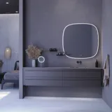 Stort badeværelse inspiration med grå vaskeskab med integreret greb, stilfuld sidestillet håndvask, firkantet spejl med afrundede hjørner, vægge i beton look samt rå materialer giver et urban udtryk