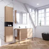 Badeværelse inspiration med vaskeskabe samt overskabe i lys eg med lameller, elegant dobbelt håndvask, smukt spejlskab med lys, sildebensgulv i lys træ og hvid marmorvæg giver et klassisk, lyst og stilrent udtryk.