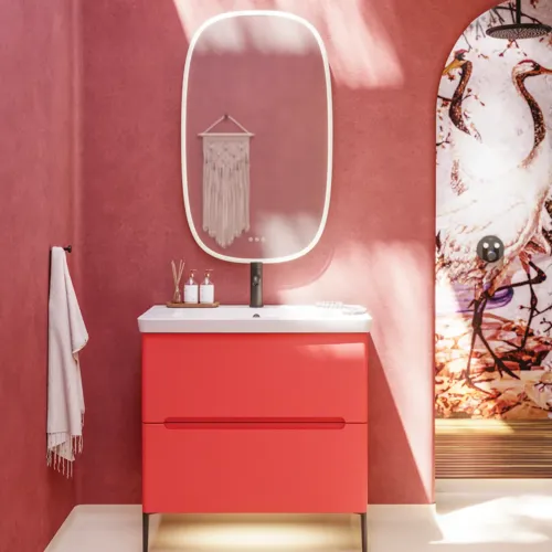 Badeværelse inspiration med røde vægge, blødt formede røde vaskeskabe og højskab, elegant hvid håndvask og smukt ovalt spejl med lys, der sammen med de naturlige omgivelser skaber et vintage udtryk