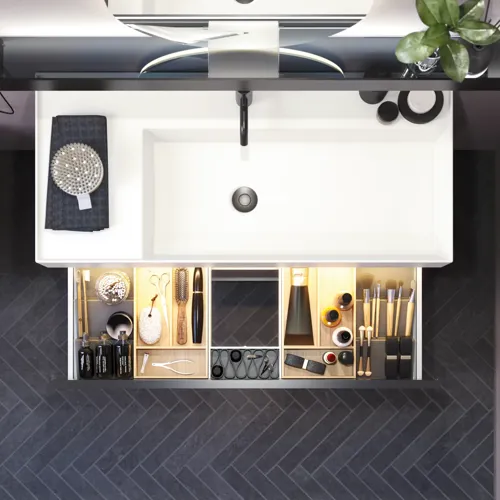 Badeværelse med skrå vægge inspiration, med badeværelsesmøbler i lilla med elegante rammefronter, flot ovalt spejl med lampe, smuk og praktisk hylde, samt lillamalet væg og gråt sildebensgulv, der giver et elegant og moderne udtryk.